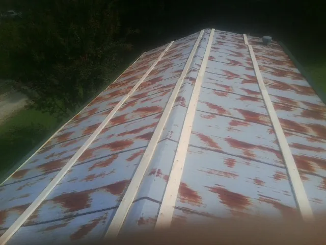 Rusted metal roof panels with new wood purlins before replacement — Storm Damage Roof Repair in Atoka by Roofing Brothers