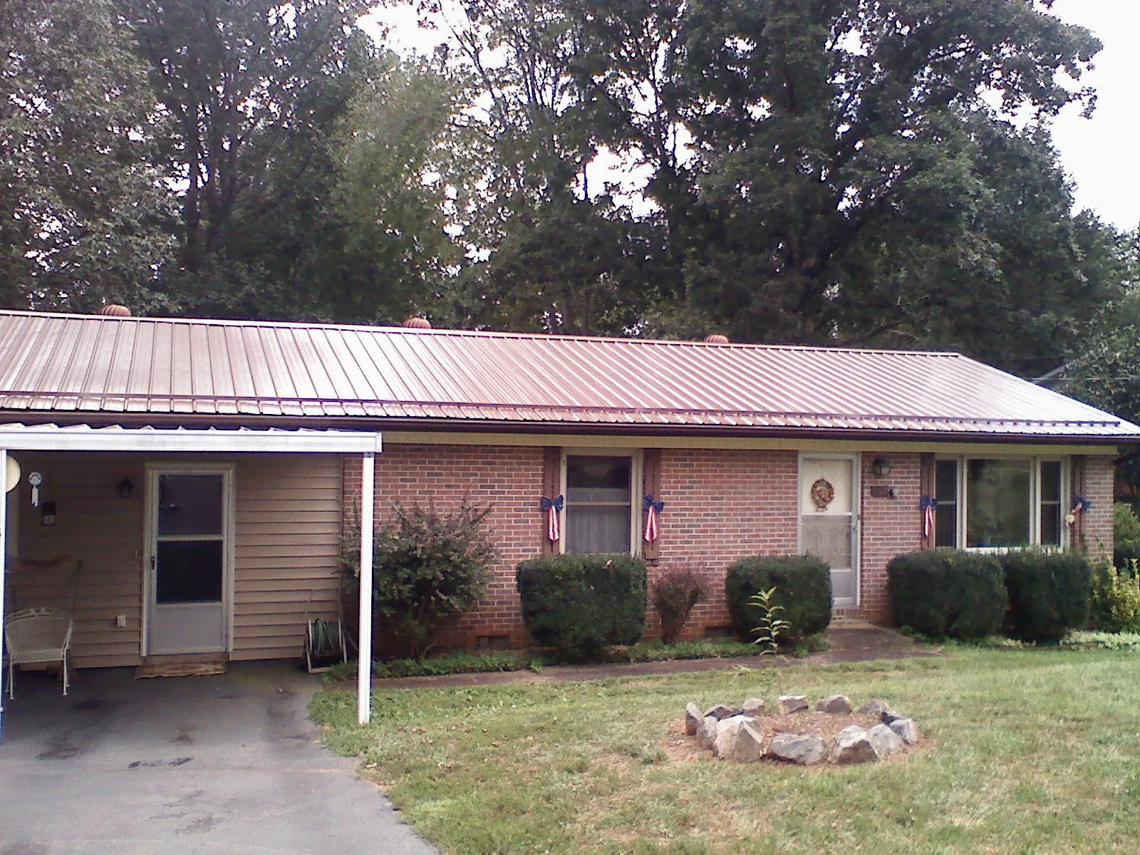 Bronze metal roof and carport on a brick ranch home — Roof Repair work by our crew in Atoka