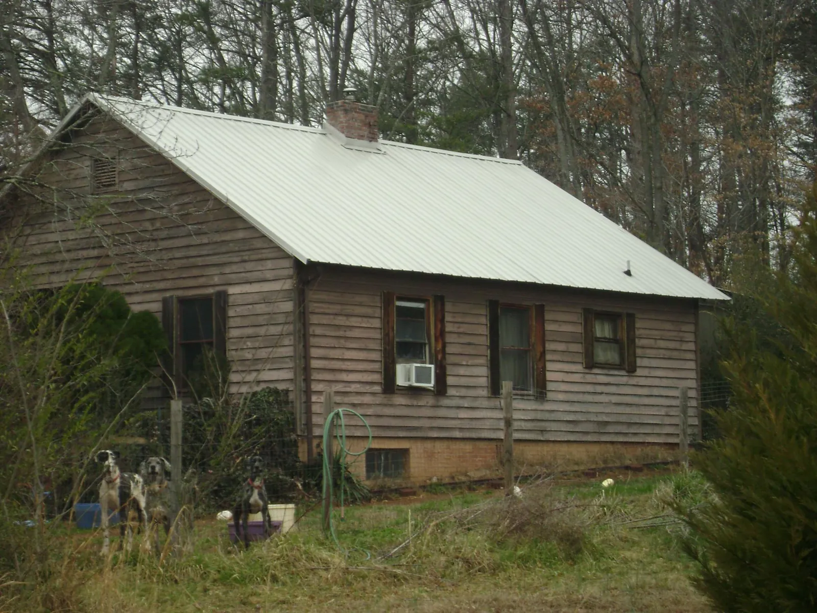 White metal roof on an old wood sided farmhouse, from a Asphalt Shingle Roof Repair job in Atoka